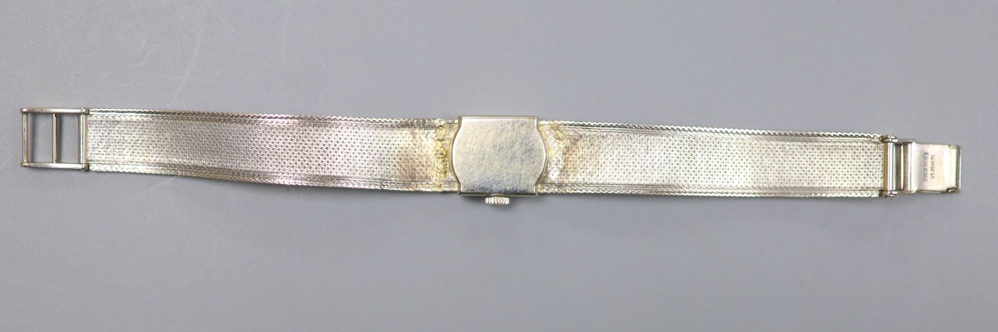 A ladys textured 9ct white gold Tissot manual wind bracelet wrist watch, overall length 17cm, gross 22 grams.